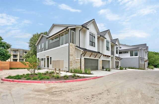 2707 Dulce Ln Unit 12, Austin, TX 78704 - view of front facade featuring stone siding, an attached garage, a standing seam roof, concrete driveway, and metal roof