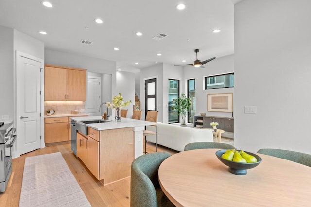 2707 Dulce Ln Unit 12, Austin, TX 78704 - kitchen featuring light brown cabinetry, a sink, a kitchen island with sink, recessed lighting, and appliances with stainless steel finishes
