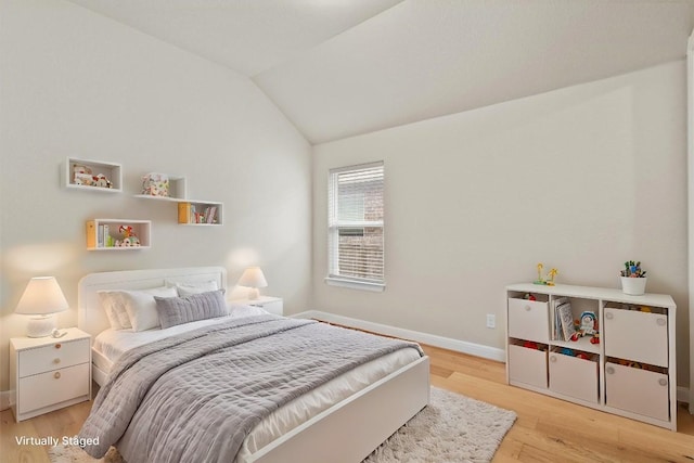 bedroom featuring light hardwood / wood-style floors and vaulted ceiling