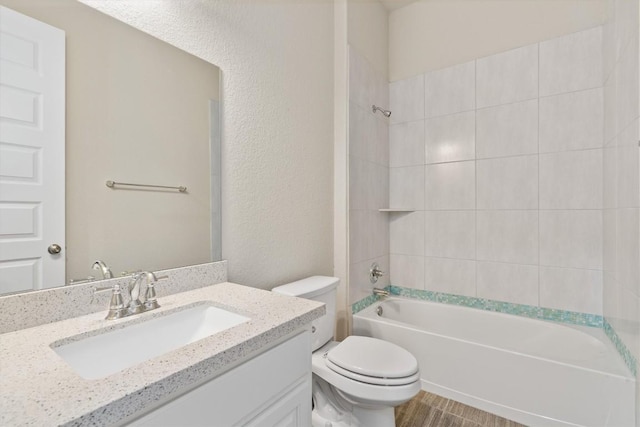 full bathroom featuring vanity, toilet, and tiled shower / bath combo