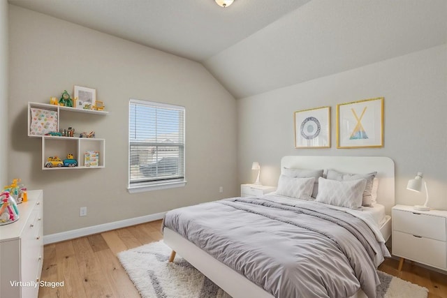 bedroom featuring lofted ceiling and light hardwood / wood-style floors