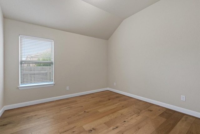 unfurnished room with lofted ceiling and light wood-type flooring