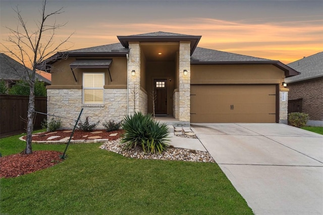 prairie-style home with a garage and a lawn