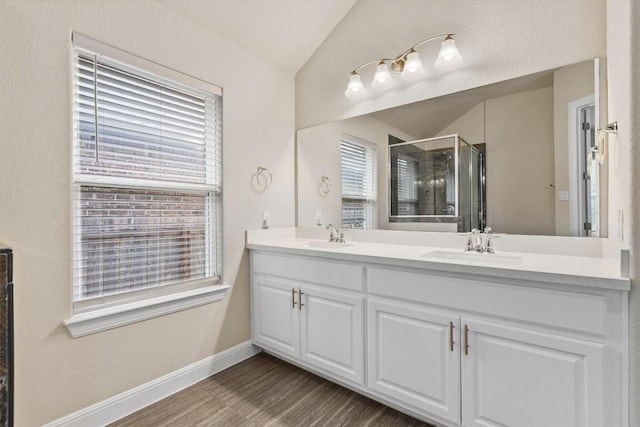 bathroom featuring vaulted ceiling, wood-type flooring, vanity, and walk in shower