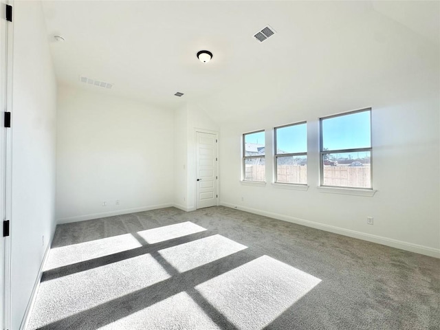 unfurnished room featuring vaulted ceiling and light carpet