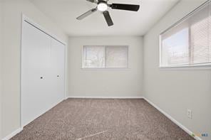 spare room with carpet, a healthy amount of sunlight, and ceiling fan