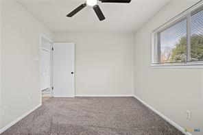 carpeted spare room with ceiling fan