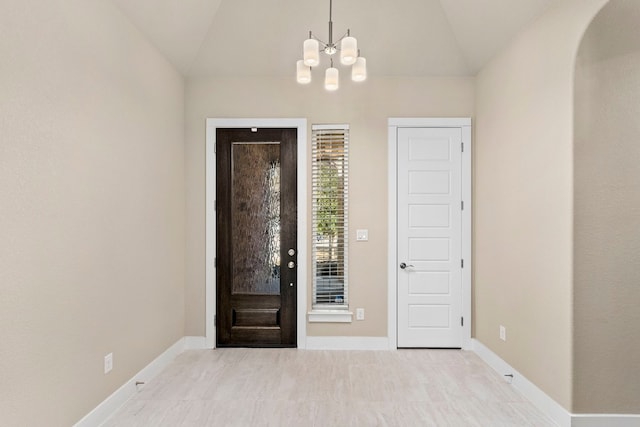 foyer entrance with lofted ceiling and a chandelier