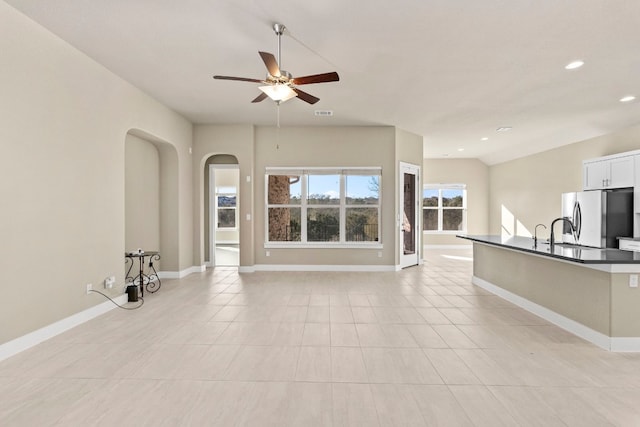 unfurnished living room featuring light tile patterned flooring, lofted ceiling, and ceiling fan