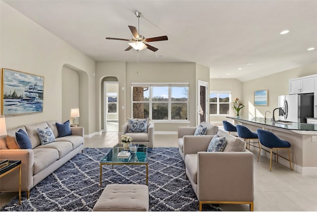 tiled living room featuring sink, vaulted ceiling, and ceiling fan