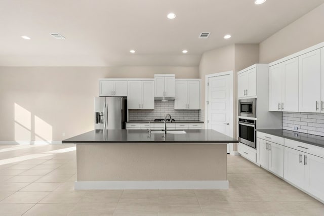 kitchen featuring sink, white cabinetry, tasteful backsplash, a center island with sink, and appliances with stainless steel finishes