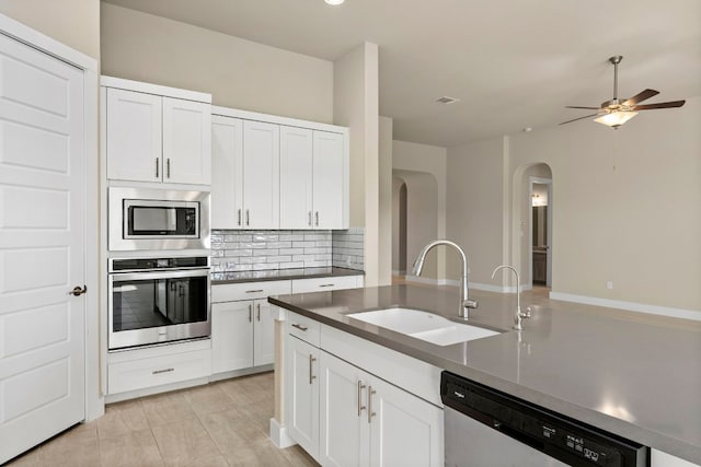 kitchen featuring sink, ceiling fan, appliances with stainless steel finishes, white cabinetry, and backsplash