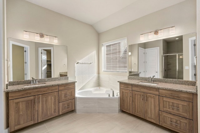 bathroom featuring tile patterned floors, vanity, shower with separate bathtub, and vaulted ceiling