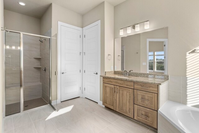 bathroom featuring vanity, shower with separate bathtub, and tile patterned flooring