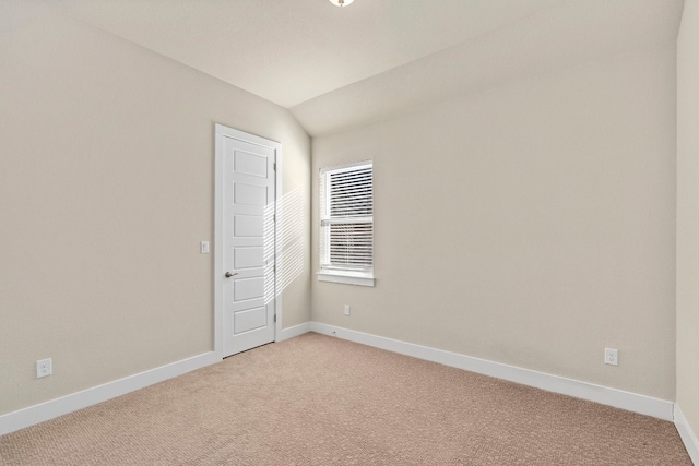 empty room featuring lofted ceiling and carpet floors