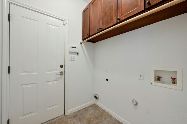 10104 Hibiscus Cv, Austin, TX 78739 - laundry area with cabinet space, hookup for an electric dryer, washer hookup, baseboards, and light tile patterned floors