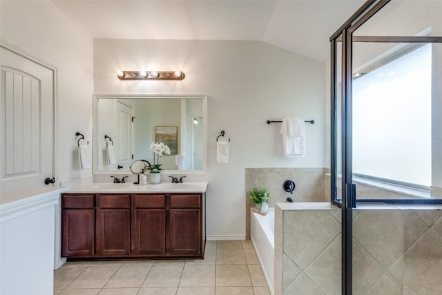 full bathroom with tile patterned floors, a sink, vaulted ceiling, and plenty of natural light