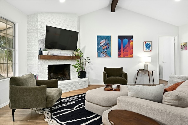 living room featuring hardwood / wood-style flooring, a brick fireplace, and vaulted ceiling with beams