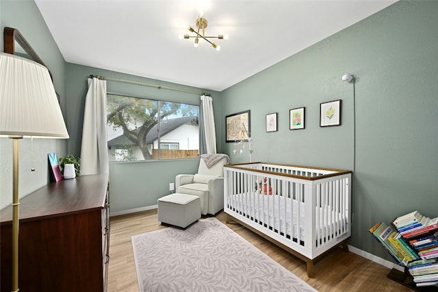 bedroom featuring a chandelier and light hardwood / wood-style floors