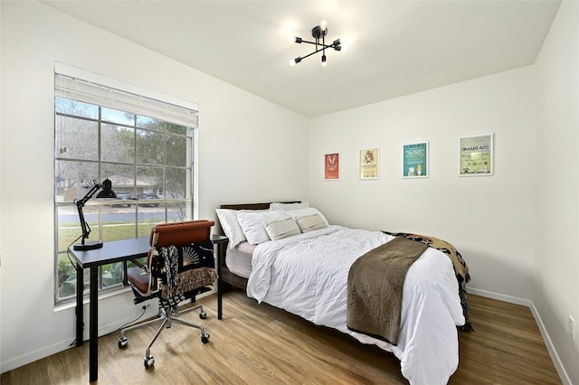 bedroom with hardwood / wood-style floors and multiple windows