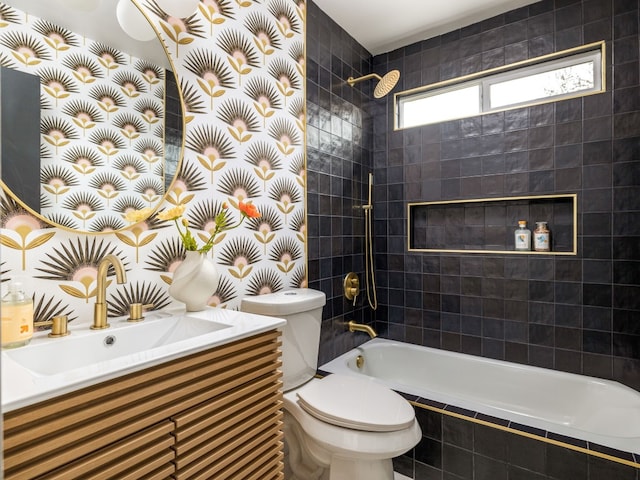 bathroom featuring toilet, tiled shower / bath, and vanity