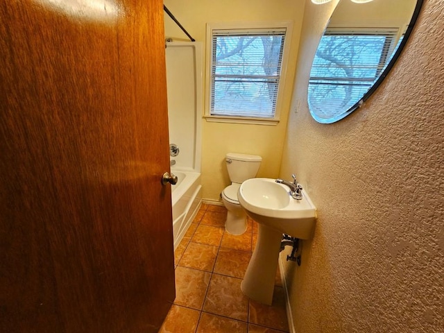 bathroom with tile patterned flooring, toilet, and shower / bathing tub combination