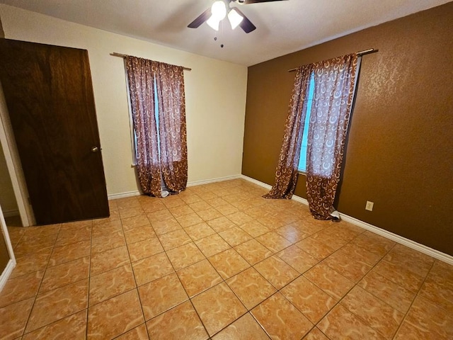 spare room featuring light tile patterned floors and ceiling fan