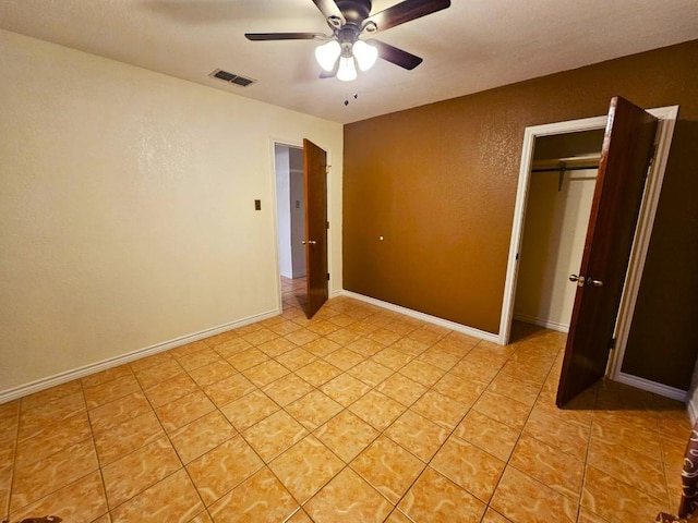 unfurnished bedroom with ceiling fan, a closet, and light tile patterned floors