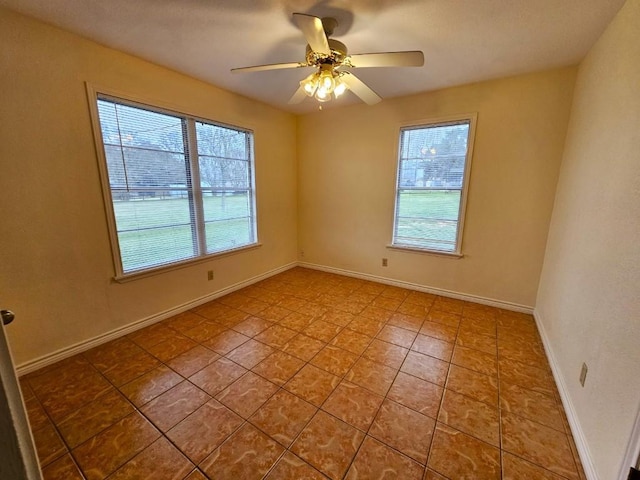 tiled spare room with a wealth of natural light and ceiling fan