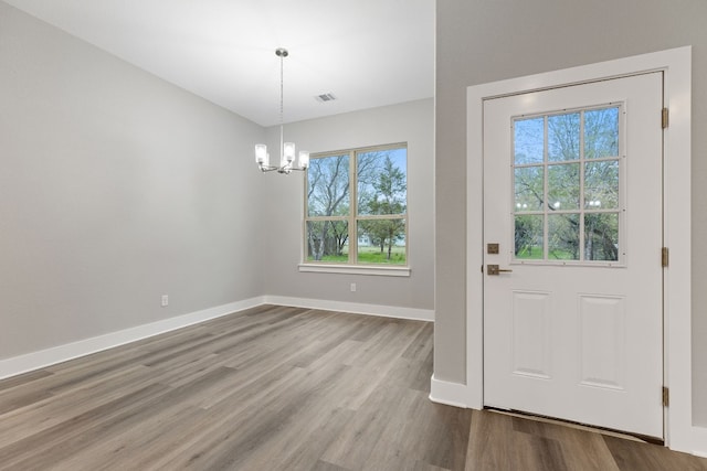 doorway featuring light hardwood / wood-style floors and a chandelier