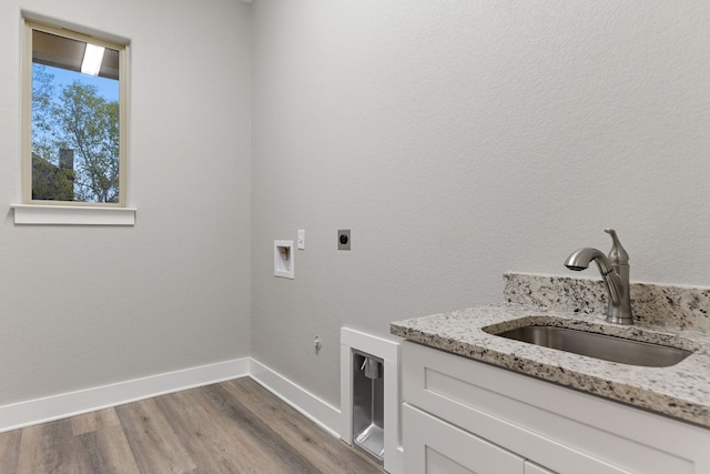 laundry area with sink, hookup for a gas dryer, washer hookup, electric dryer hookup, and light wood-type flooring