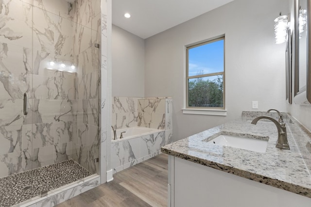 bathroom featuring vanity, hardwood / wood-style flooring, and plus walk in shower