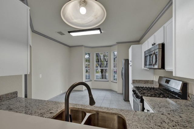 kitchen featuring sink, crown molding, white cabinetry, stainless steel appliances, and light stone countertops