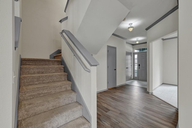 entryway with crown molding and hardwood / wood-style floors