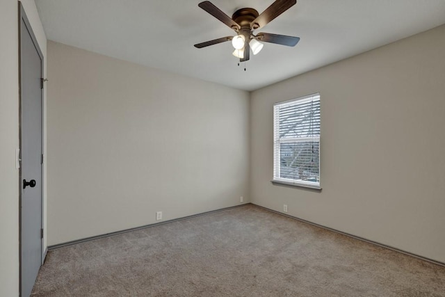 spare room with ceiling fan and light colored carpet