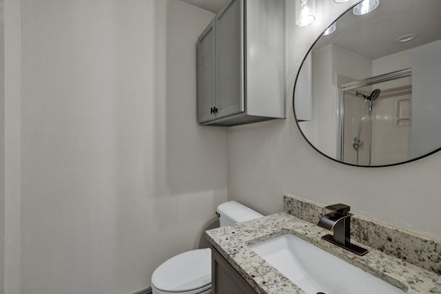 bathroom featuring vanity, an enclosed shower, and toilet