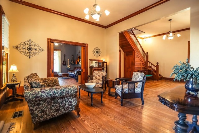 living room featuring ornamental molding, hardwood / wood-style floors, and a notable chandelier