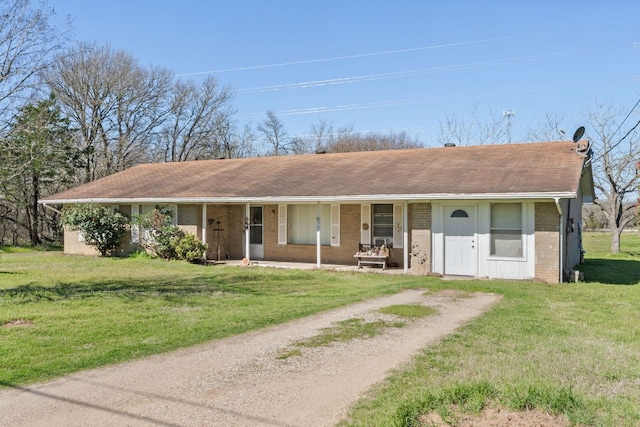 single story home featuring a porch, brick siding, driveway, and a front lawn