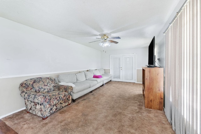 living room with light carpet, ceiling fan, and a textured ceiling