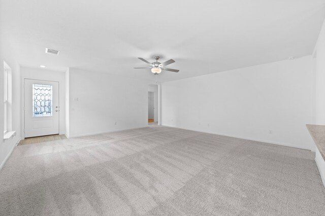 unfurnished living room with ceiling fan and light carpet