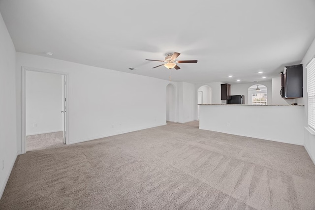 unfurnished living room featuring carpet flooring and ceiling fan