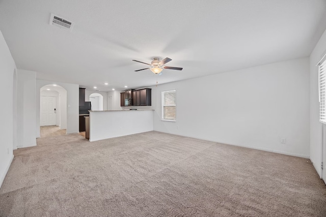 unfurnished living room with light carpet and ceiling fan