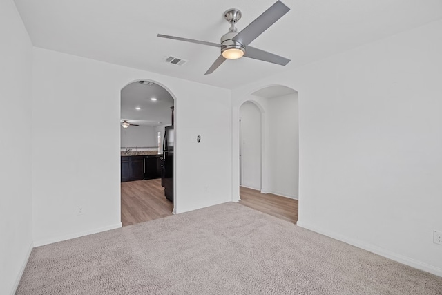 carpeted spare room featuring ceiling fan