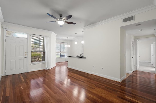 unfurnished living room with ceiling fan, dark wood-type flooring, and crown molding