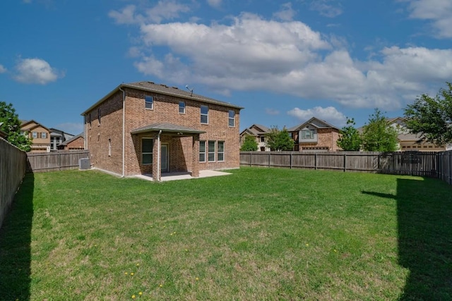 rear view of property featuring a patio, a yard, and central AC