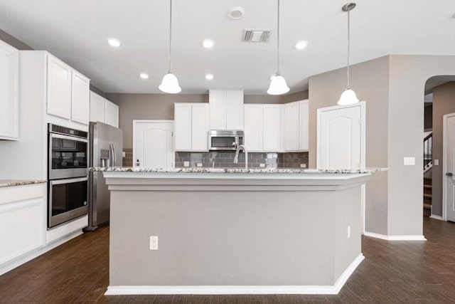 kitchen featuring pendant lighting, white cabinetry, stainless steel appliances, and an island with sink