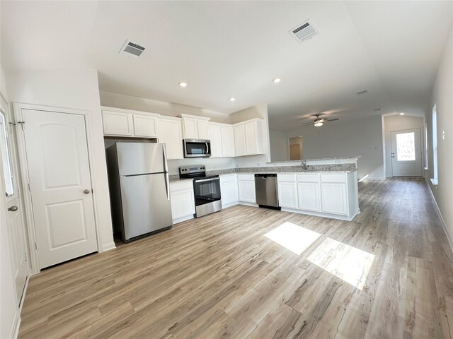 kitchen with stainless steel appliances, open floor plan, visible vents, and white cabinets