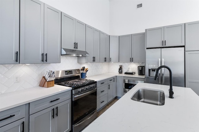 11233/4 Gunter St Unit 2, Austin, TX 78702 - kitchen featuring visible vents, appliances with stainless steel finishes, under cabinet range hood, a sink, and gray cabinetry