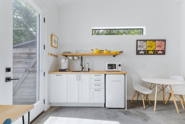 11233/4 Gunter St Unit 2, Austin, TX 78702 - bar featuring white microwave, concrete floors, a sink, and a healthy amount of sunlight