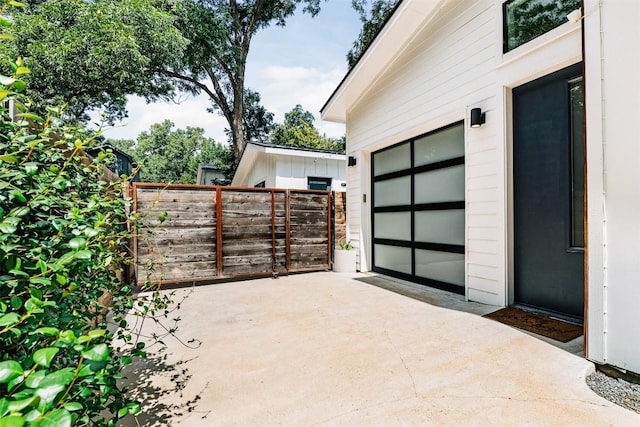 11233/4 Gunter St Unit 2, Austin, TX 78702 - view of patio featuring concrete driveway, a garage, and fence